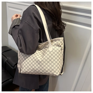 Side view of large tote bag with M-pattern print on model in minimalist interior