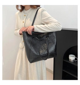 Vue détaillée du sac cabas en cuir noir façon crocodile avec double anse et bandoulière