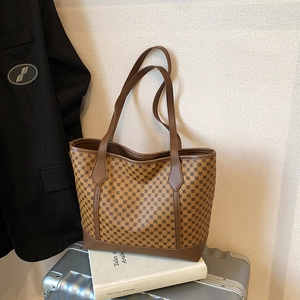 Retro large capacity tote bag with geometric print and brown leather handles on luggage