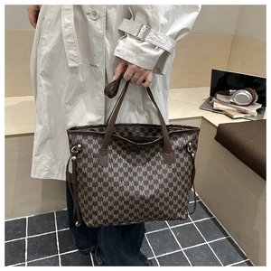 Close-up of large tote bag featuring vintage M letter jacquard pattern and adjustable side straps