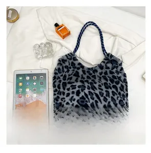 Close-up of leopard print plush tote bag featuring blue and black woven rope handles