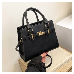 Detailed macro view of black matte PU leather tote with classic golden twist lock hardware