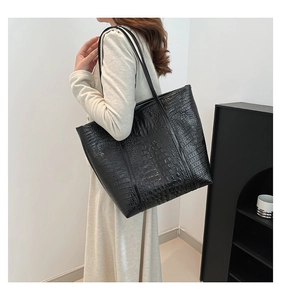 Vue latérale du grand sac cabas noir avec motif crocodile porté par un mannequin