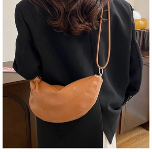Brown half-moon crossbody bag detail with decorative stitching on textured leather