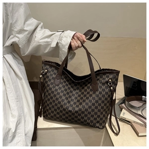 Detail of vintage tote bag with M-letter monogram and durable leather handles in urban setting