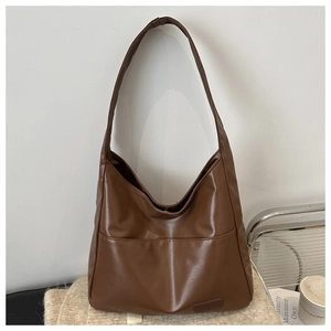 Dettaglio della borsa tote marrone vintage con trama in pelle opaca e tasca frontale