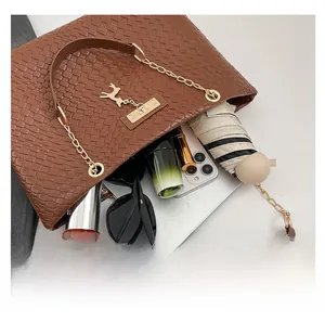 Brown woven leather tote bag showing large capacity with laptop and daily essentials