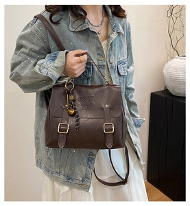Detail of dark brown retro PU leather backpack with COIN embossing and metal buckles