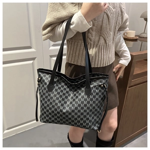 Model wearing large capacity tote bag with grey letter patterns and black straps