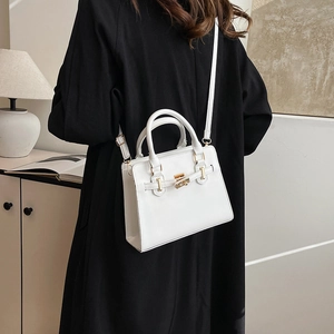 White minimalist trapezoid handbag for women featuring a top handle and shoulder strap