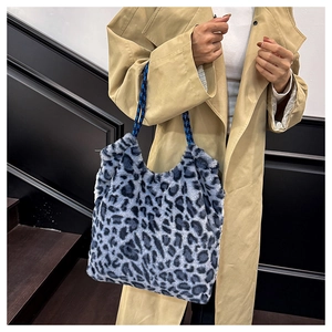 Close-up of blue leopard print faux fur tote with woven straps on a trench coat model