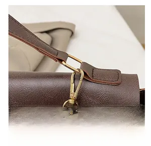 Detailed close-up of dark brown lychee texture leather with golden metal hardware hooks