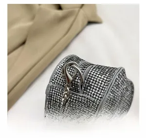 Detail of silver heart-shaped evening bag with sparkly rhinestones and metal chain
