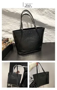 Détail du cabas noir à motif crocodile avec surface polie et fines bandoulières