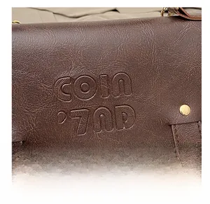 Close-up of brown lychee leather with COIN '70D embossing and gold rivet details