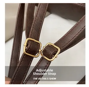 Detail of adjustable brown leather strap with golden buckle and neat stitching