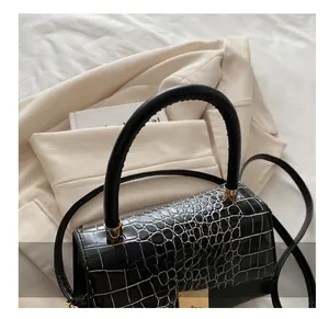 Vue détaillée du sac à main noir motif crocodile avec des finitions métalliques dorées