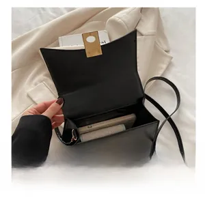 Détail montrant la capacité interne d'un sac bandoulière en cuir noir à fermoir doré