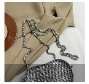 Detail showing the silver metal mesh texture and woven chain strap of heart-shaped evening bag