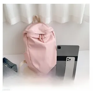 Pink nylon backpack showing large storage capacity compared with tablet and smartphone