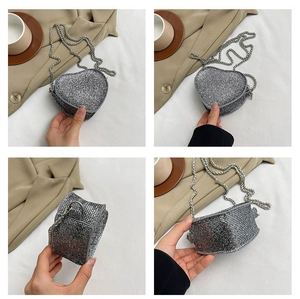 Detail shots of sparkling heart-shaped evening bag with silver chain and rhinestones