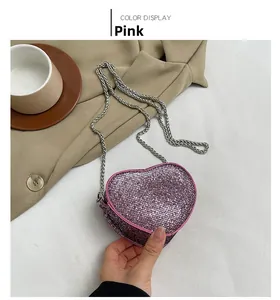 Close-up of heart-shaped pink rhinestone mini bag with elegant silver chain strap
