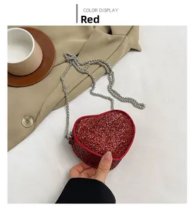 Detail of red heart-shaped evening bag with glittering rhinestones and silver chain