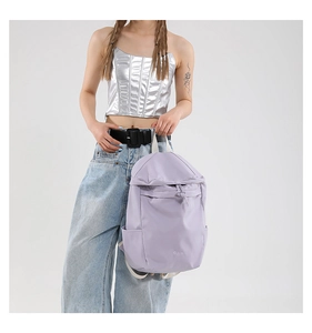 Detail view of lavender nylon backpack with flap closure and drawstring design
