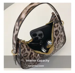 Internal capacity of leopard print crescent bag showing smartphone and lipstick storage