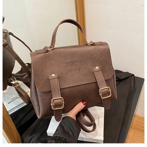 Detail shot of the brown retro tote bag showing pebbled leather texture and double buckles