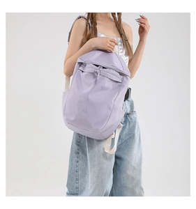 Close-up of lavender nylon backpack with drawstring closure and BAG text embroidery