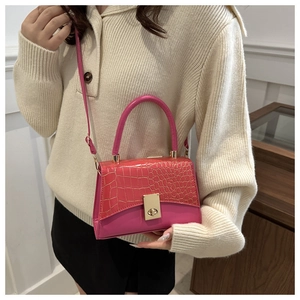 Détail du sac fuchsia avec texture crocodile gaufrée et fermoir en métal doré chic