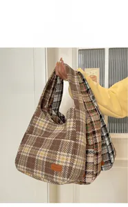 Close-up of vintage plaid tote bag made of thick wool fabric with leather patch detail
