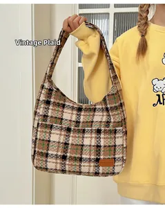 Close-up of retro plaid tote bag texture with brown leather fashion brand tag