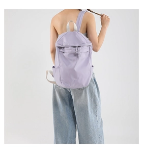 Detailed back view of a light purple lightweight nylon backpack shown on a model's back