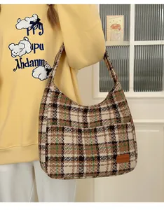 Brown and green plaid hobo tote bag shown on shoulder for daily commute style