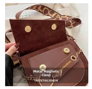 Détail du sac selle marron foncé mat avec fermoir magnétique doré et bandoulière large