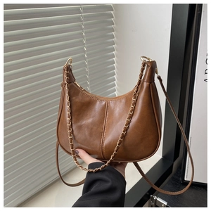 Détail du sac demi-lune vintage marron avec chaîne dorée et texture en PU lisse