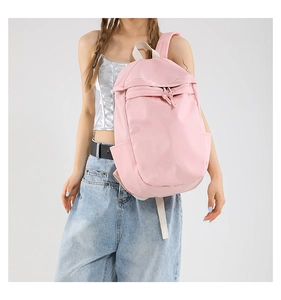 Detailed view of pink nylon backpack showing soft texture and front zipper pocket detail