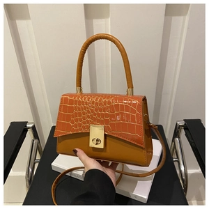 Détail de la texture cuir gaufré crocodile et fermoir doré sur ce sac à main chic