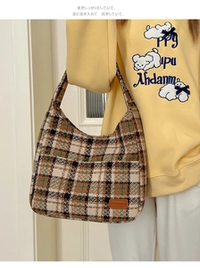 Close-up of retro plaid hobo bag featuring thick woven texture and leather logo tag