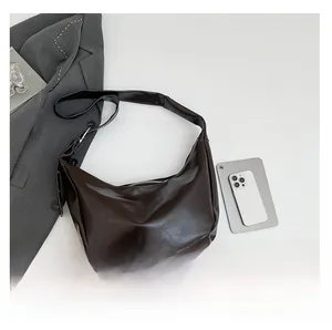 Vista dettagliata della borsa hobo marrone scuro con trama in pelle liscia e zip in metallo