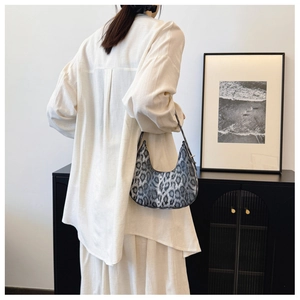 Detail view of the gray leopard print crescent hobo bag styled with a white linen shirt