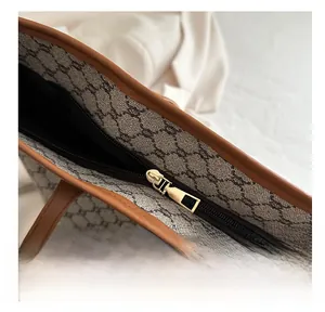 Detailed macro view of smooth gold zipper and vintage monogram canvas tote bag