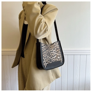 Detail of leopard print stitching and leather shoulder strap on a chic handbag