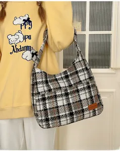 Detail of vintage plaid tote bag featuring textured fabric and orange brand label
