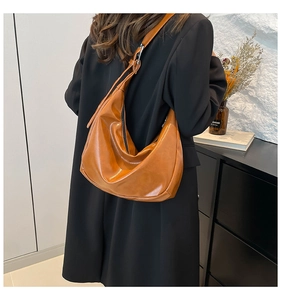 Dettaglio di una borsa hobo a mezzaluna in pelle PU marrone con tracolla regolabile