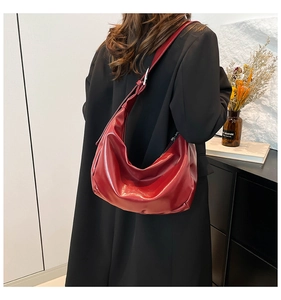 Dettaglio della borsa a tracolla in pelle PU rosso intenso lucido con fibbia in metallo regolabile