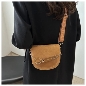 Détail du sac besace marron en daim avec chaîne métallique et large bandoulière jacquard