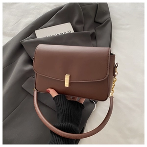 Detailansicht der braunen matten Ledertasche mit goldener Schließe und edler Kette